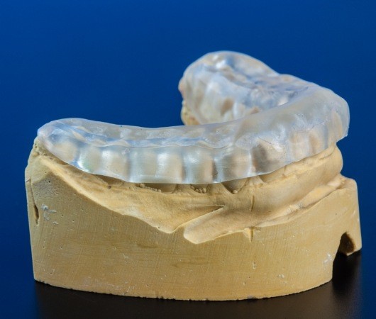 Model of lower jaw with clear nightguard over it