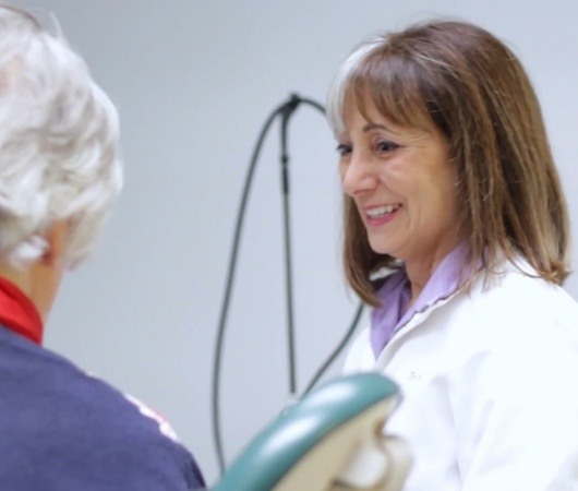 Doctor Berkal talking to patient in Derry dental office