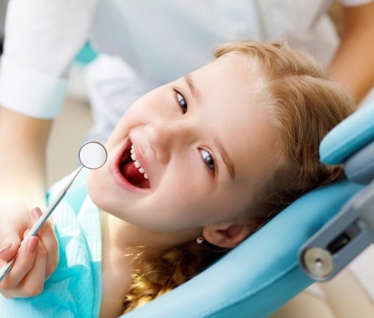 Young girl smiling right before her dental exam