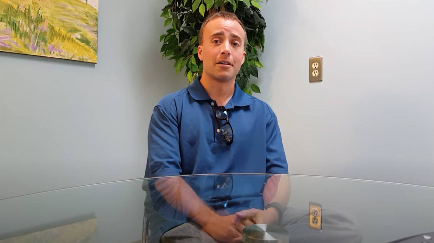 Man in blue polo shirt sitting at table